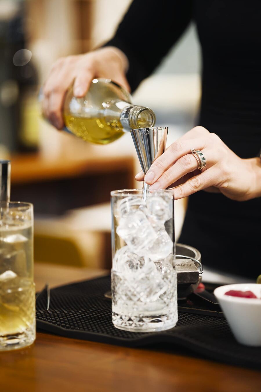 Una barista versa un drink su ghiaccio