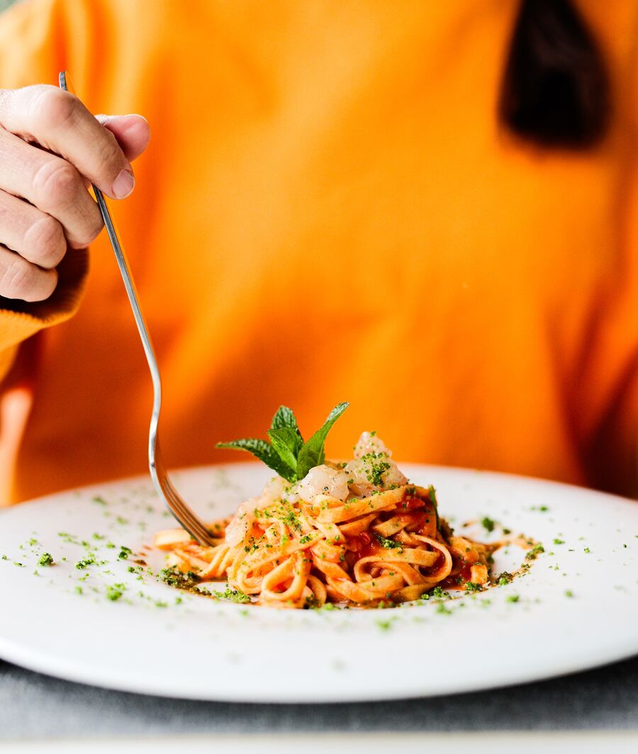 Un piatto di tagliatelle con basilico e pistacchio