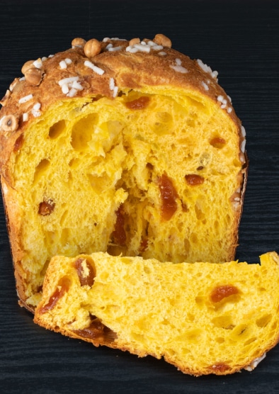 Panettone all'albicocca con glassa e nocciole, tagliato